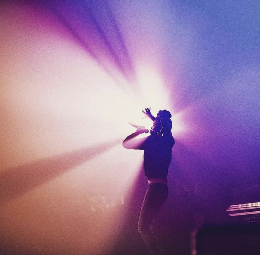 Dynasty performing on stage through colorful concert lights